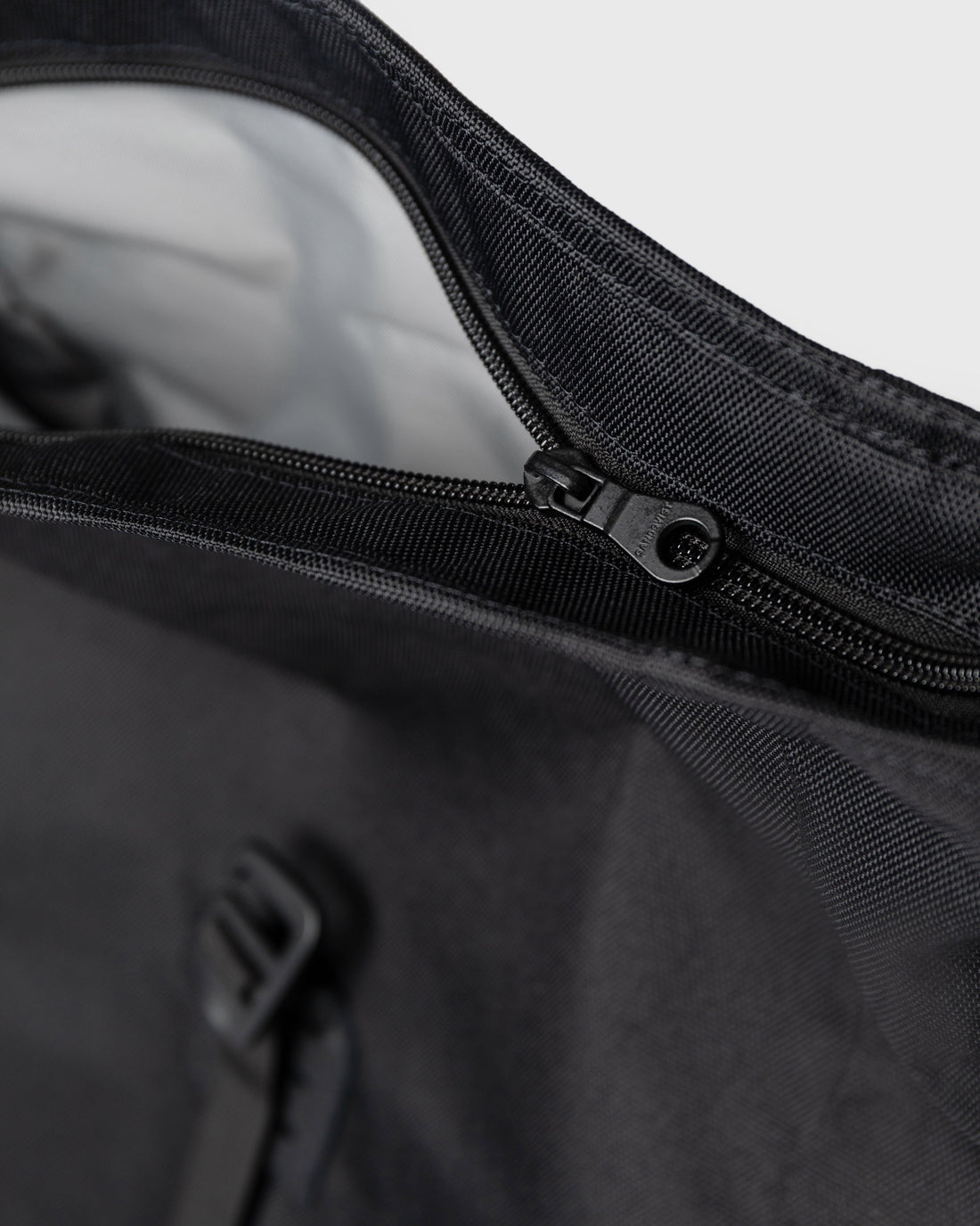 Sandqvist ICON Rolltop Backpack 16" noir — détail de la fermeture éclair supérieure et de la doublure.