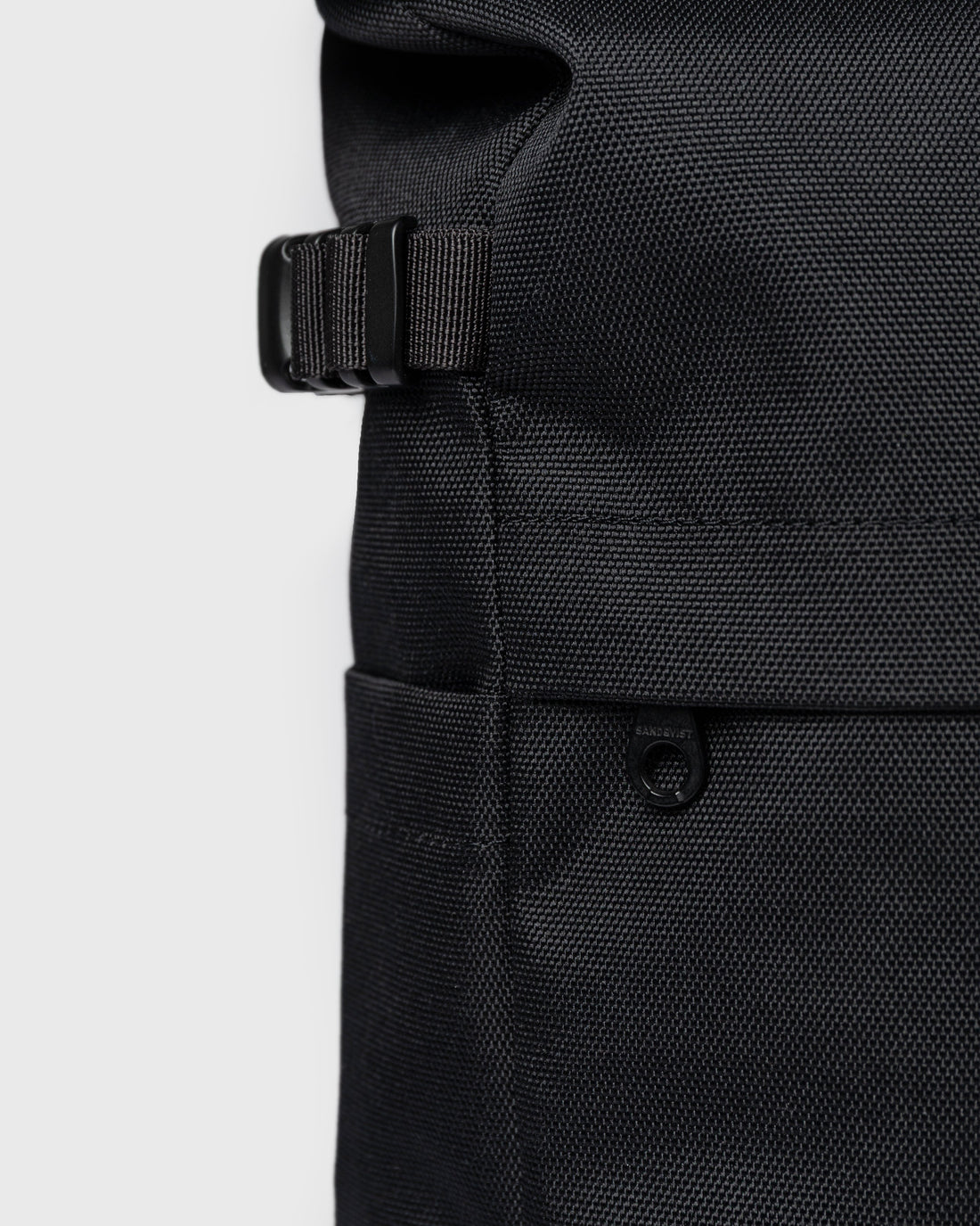 Sandqvist ICON Rolltop Backpack 14" noir — détail de la sangle latérale et des poches extérieures.