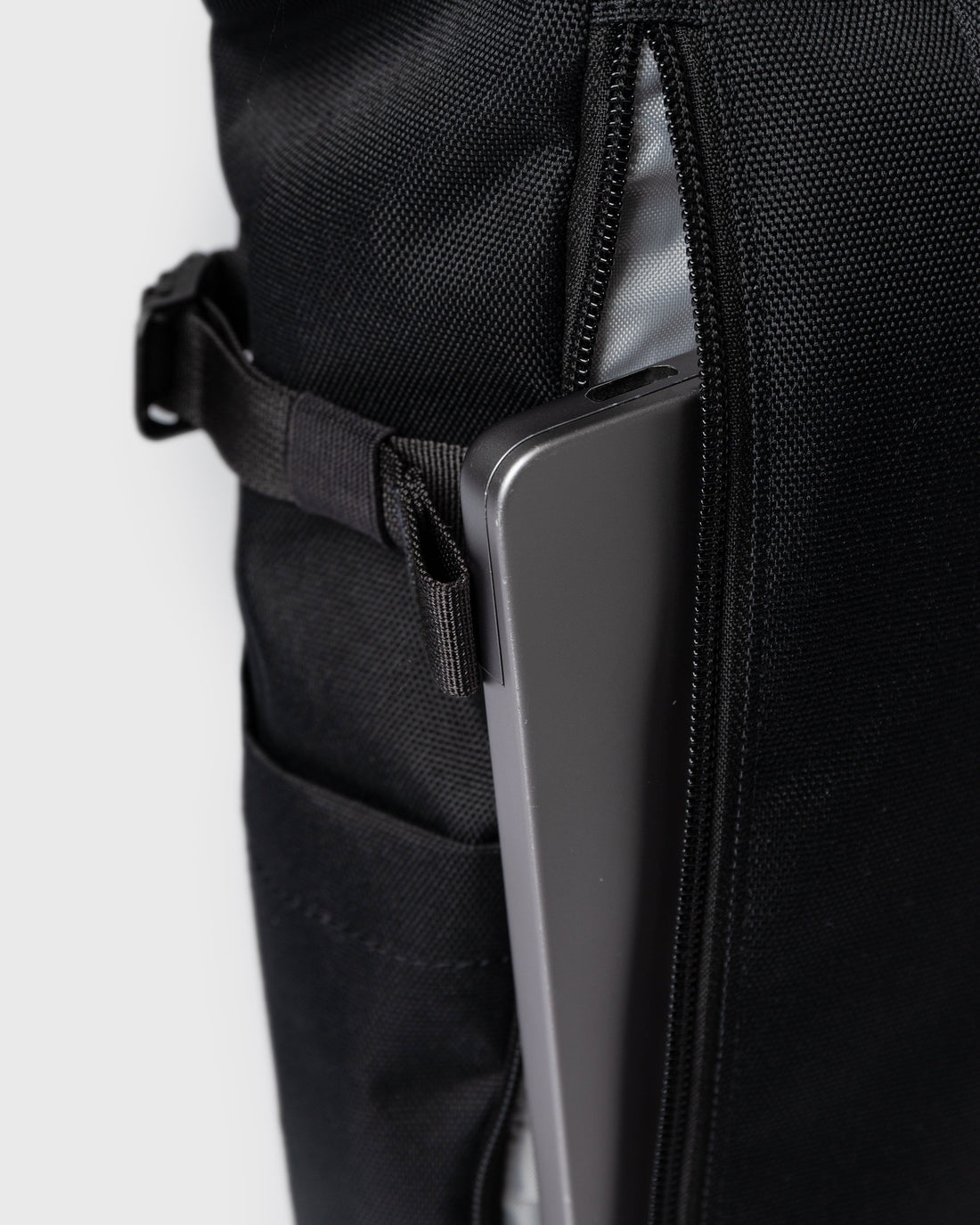 Sandqvist ICON Rolltop Backpack 14" noir — détail du compartiment dorsal avec un ordinateur portable illustrant le rangement.