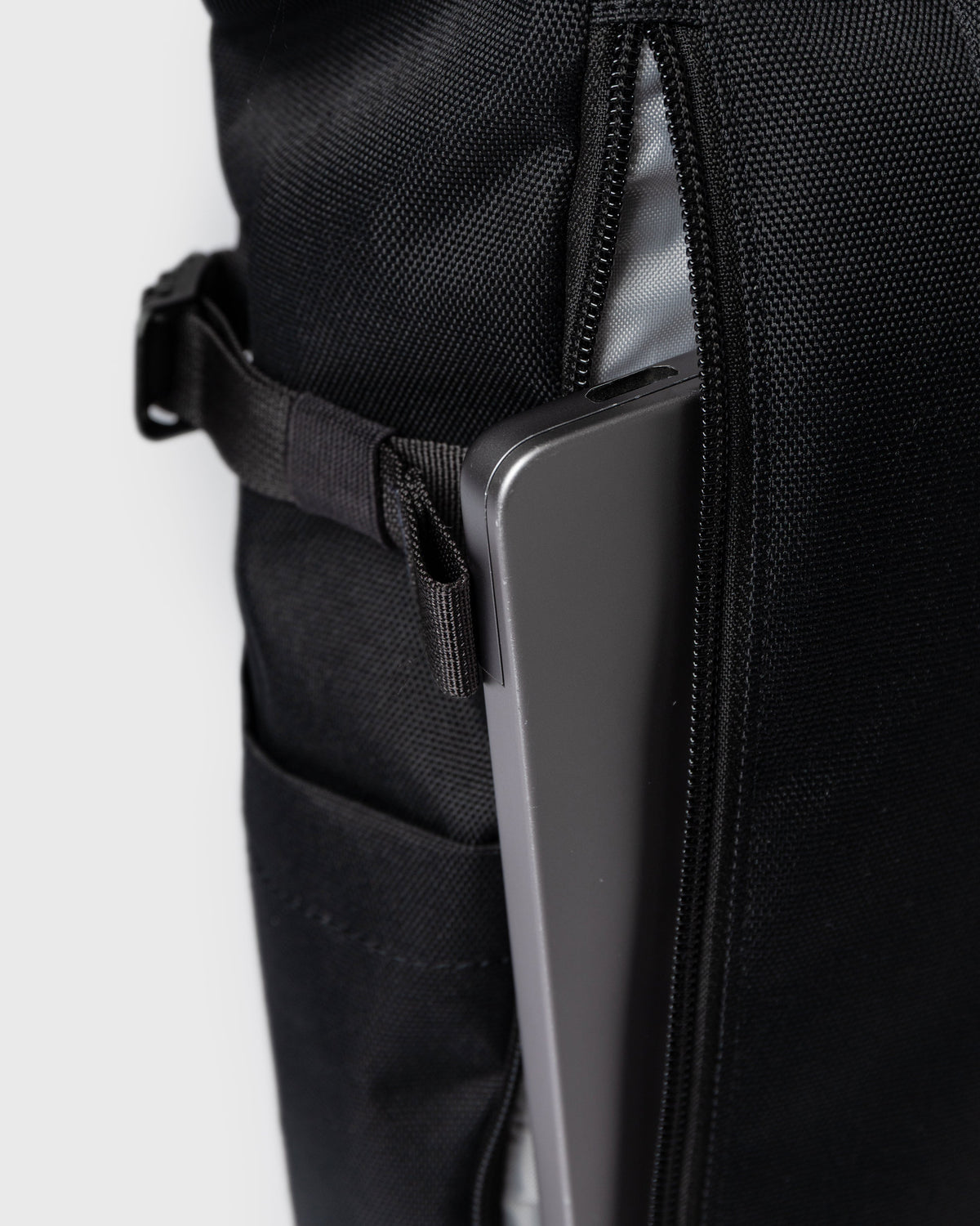 Sandqvist ICON Rolltop Backpack 14" noir — détail du compartiment dorsal avec un ordinateur portable illustrant le rangement.