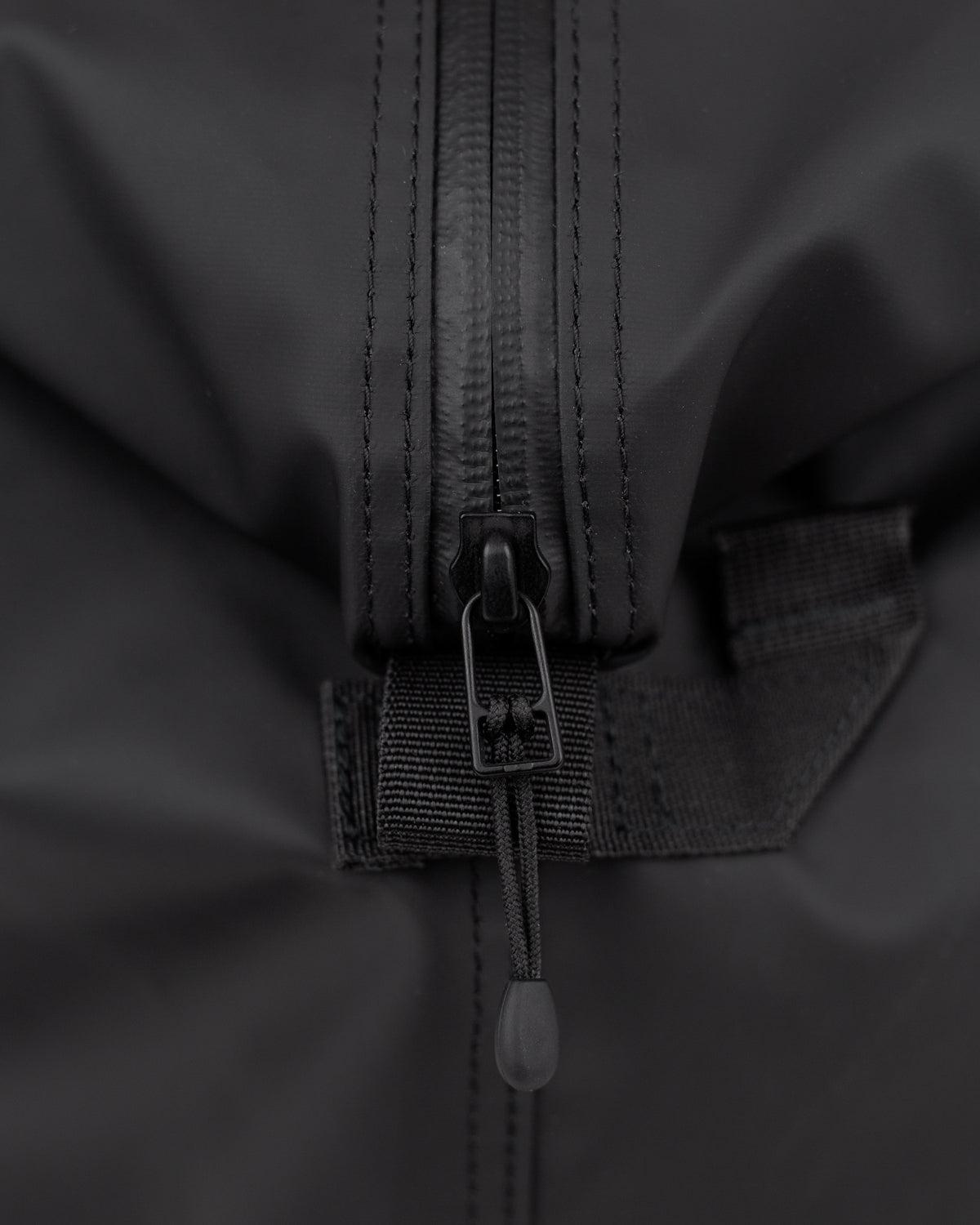 Sandqvist STREAM Weekender Bag noir — détail des fermetures éclair du compartiment principal et de la poche extérieure.