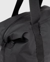 Sandqvist STREAM Weekender Bag noir — détail de l’extrémité latérale et de sa fixation.