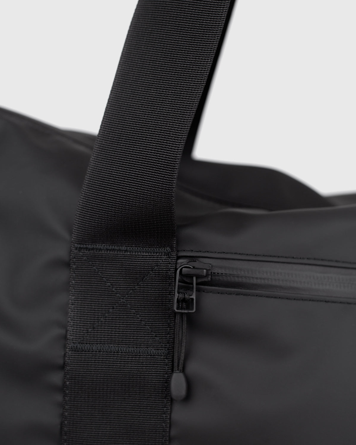 Sandqvist STREAM Weekender Bag noir — détail de la sangle et de la poche frontale zippée.