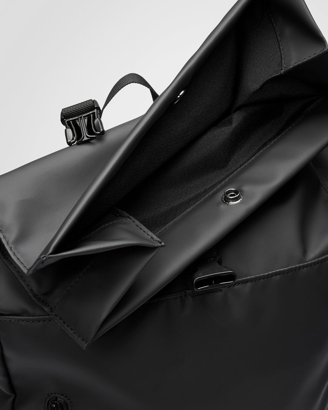 Sandqvist STREAM Rolltop Backpack 14" noir — détail de la fermeture rolltop ouverte et du bouton-pression.