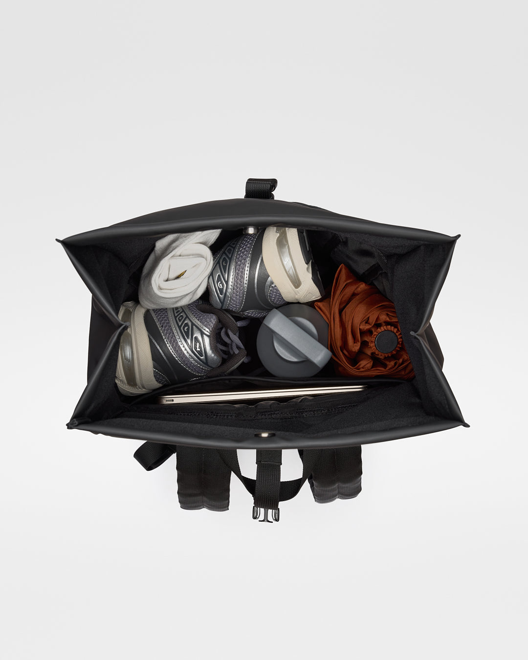 Sandqvist STREAM Rolltop Backpack 14" noir — vue intérieure par le dessus avec objets rangés pour illustrer la capacité.