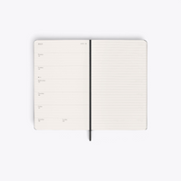Agenda Moleskine noir ouvert sur une semaine avec page de notes