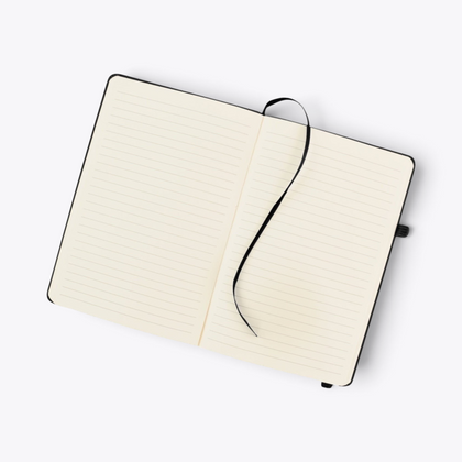 Carnet de notes noir avec porte-stylo ouvert sur ses pages lignées