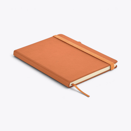 Carnet de notes orange avec porte-stylo fermé, vue de trois quarts