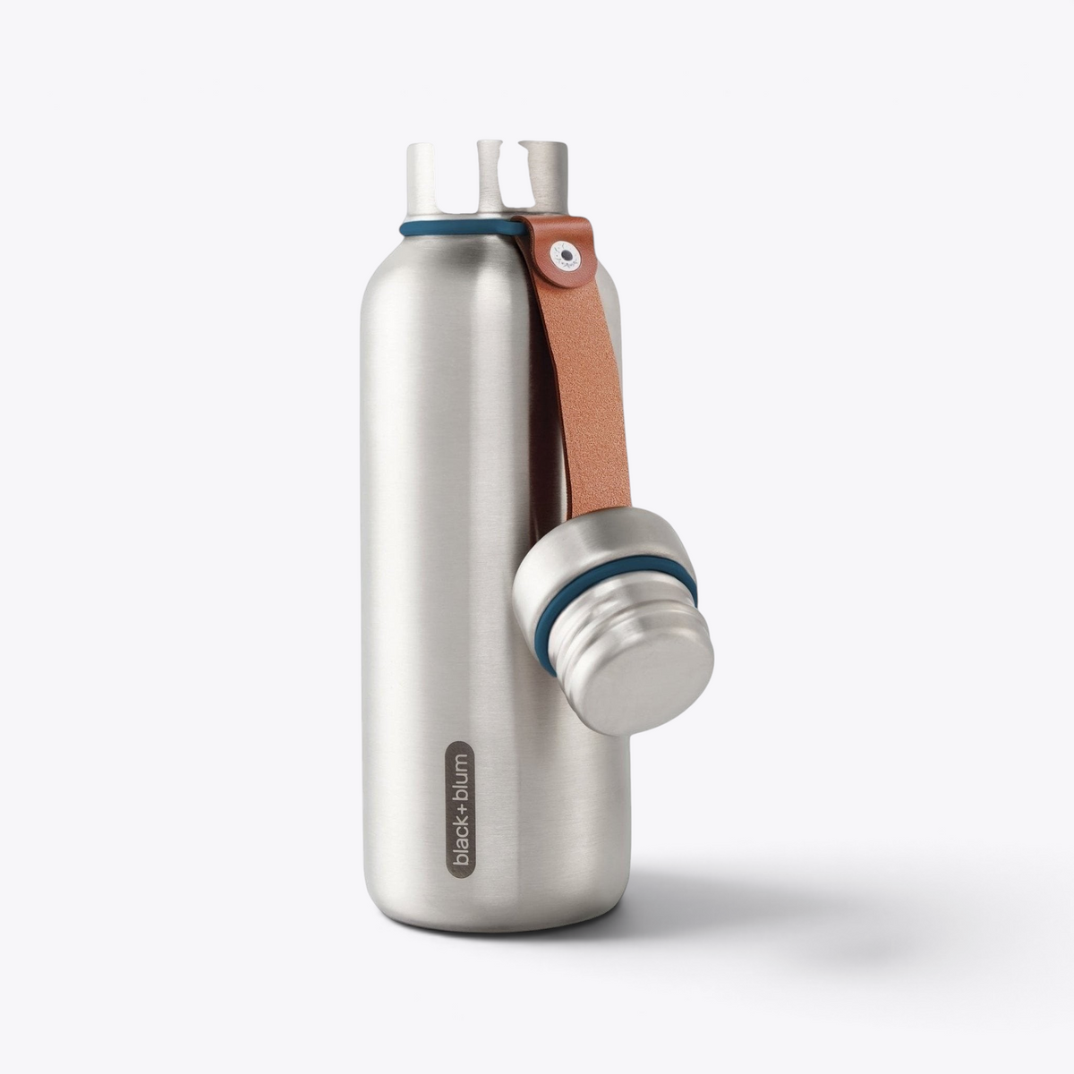 Bouteille Black+Blum argentée, anneaux bleus et sangle en cuir, bouchon suspendu