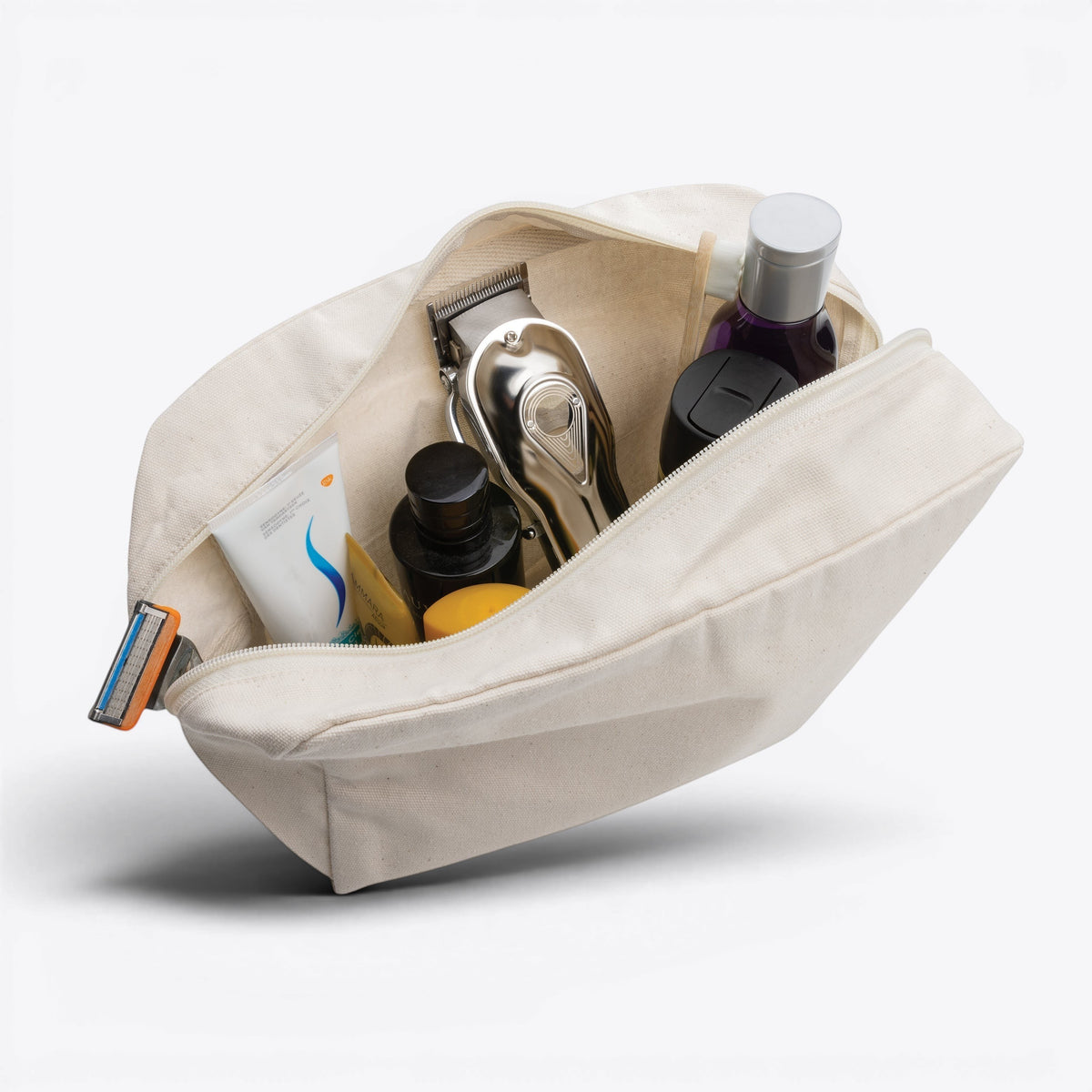 Trousse de toilette en toile recyclée non teintée Aware™ blanc cassé, vue ouverte avec contenu