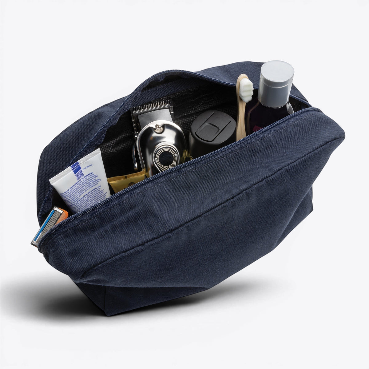 Trousse de toilette en toile recyclée non teintée Aware™ bleu marine, vue ouverte avec contenu