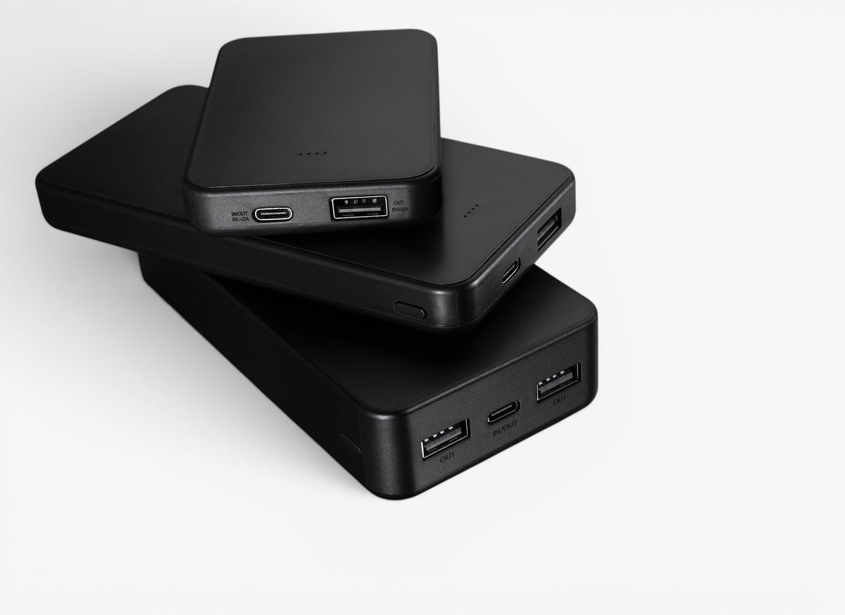 Trois batteries externes noires empilées, ports visibles