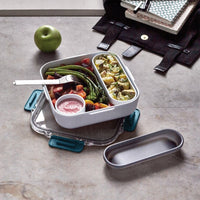 Lunchbox Black+Blum à attaches bleues ouverte avec un repas