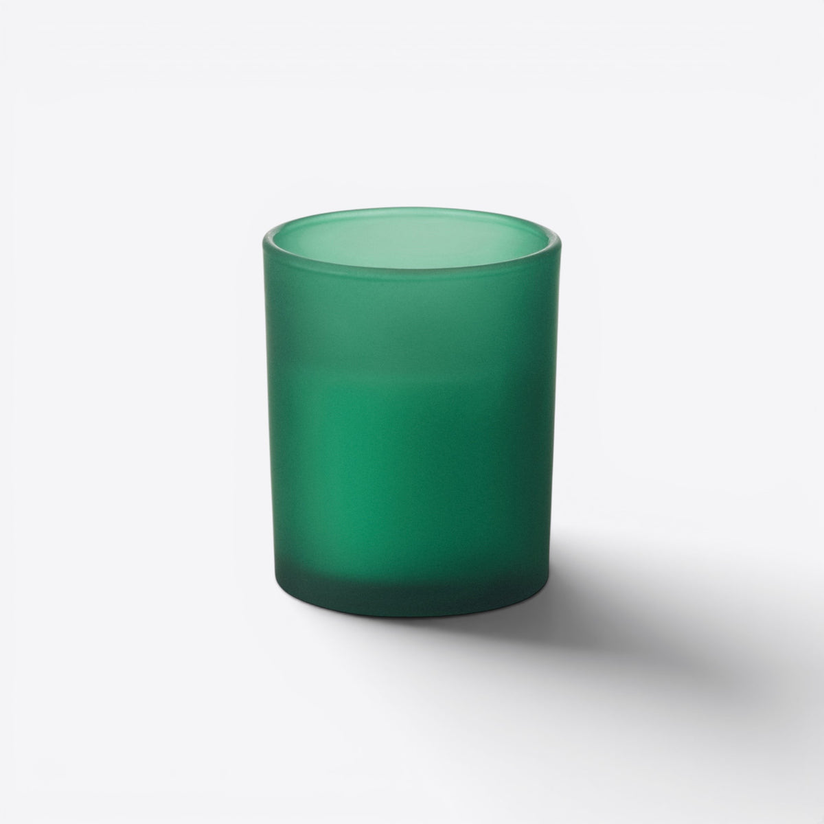 Bougie ronde dans un verre vert dépoli, vue de face