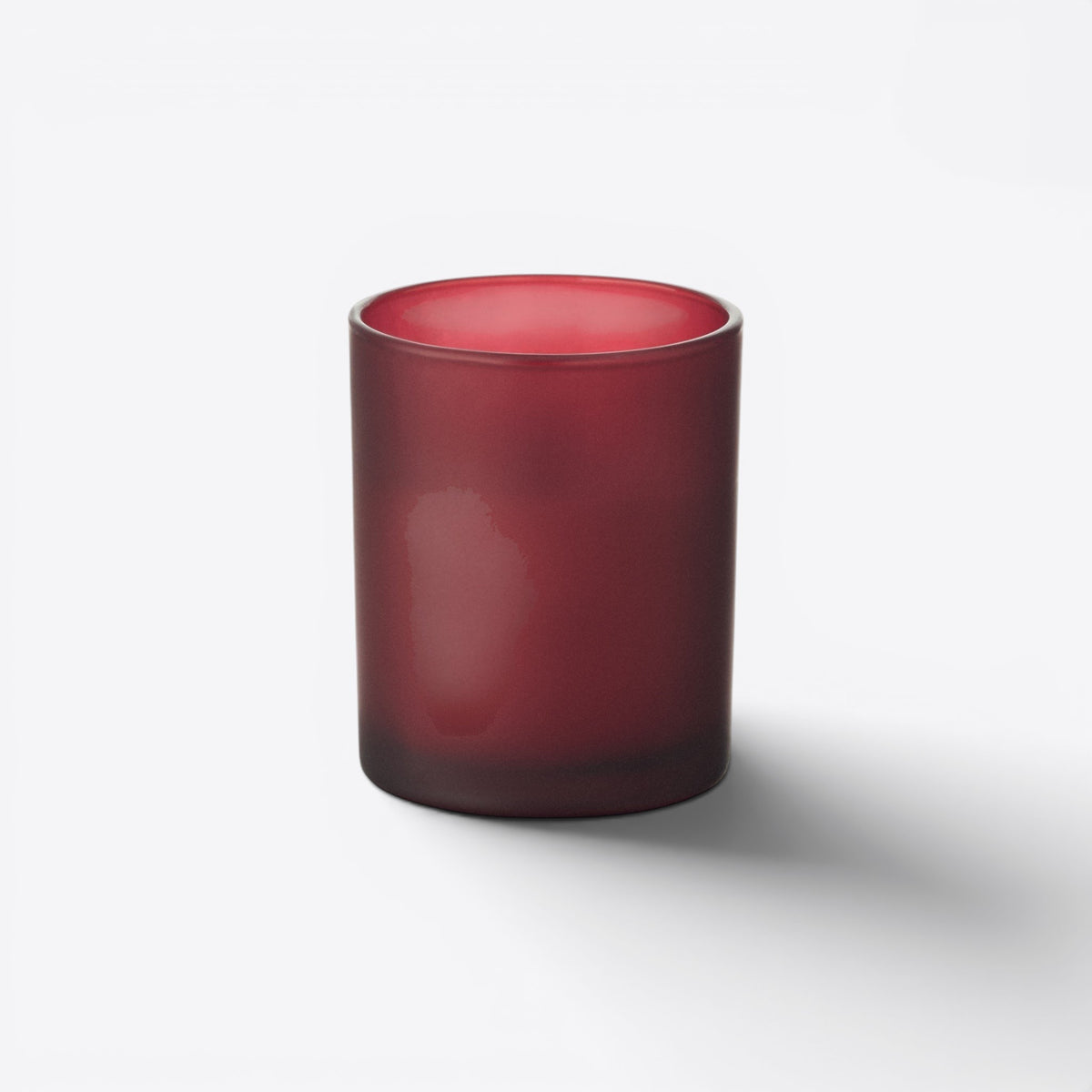 Bougie ronde dans un verre rouge dépoli, vue de face