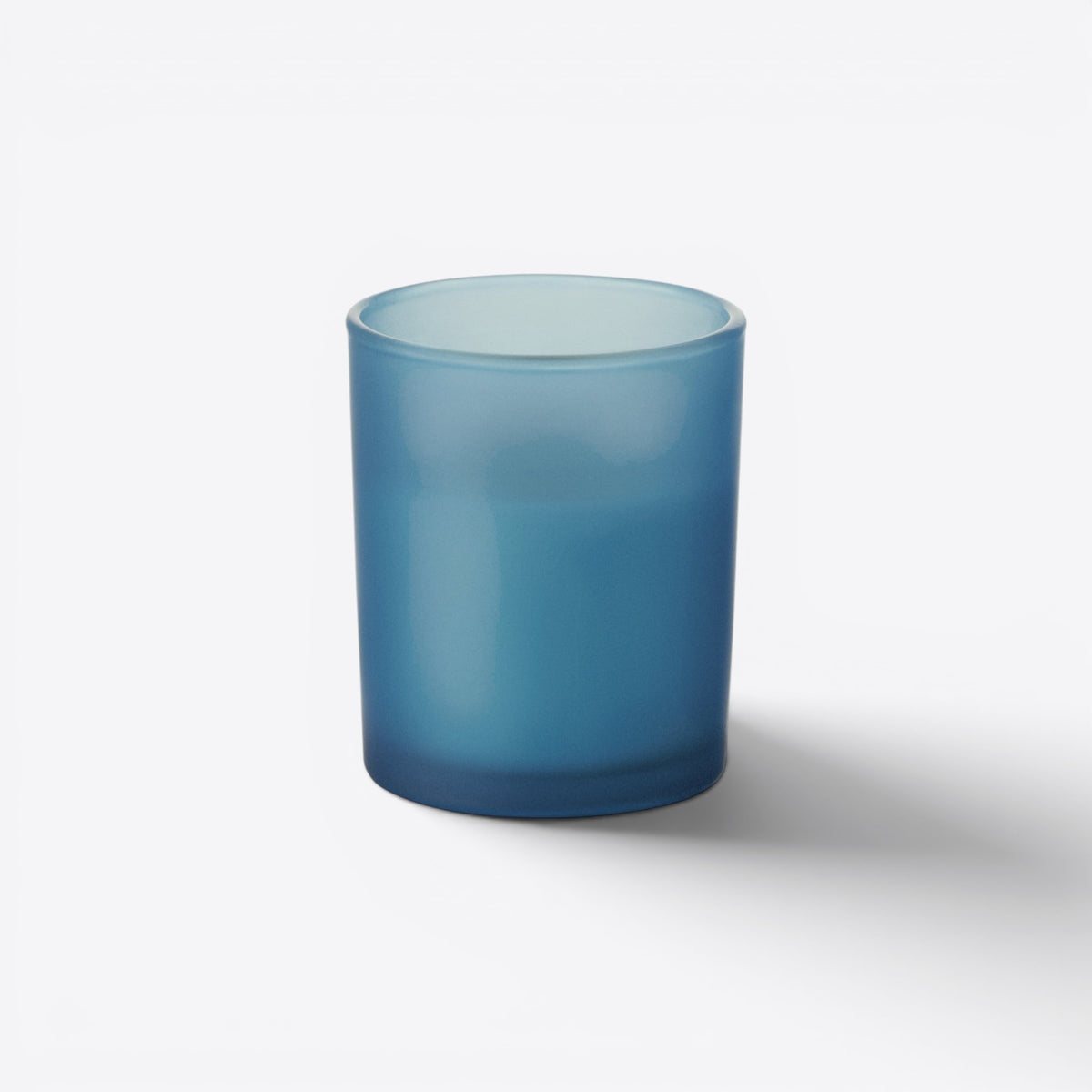 Bougie ronde dans un verre bleu dépoli, vue de face