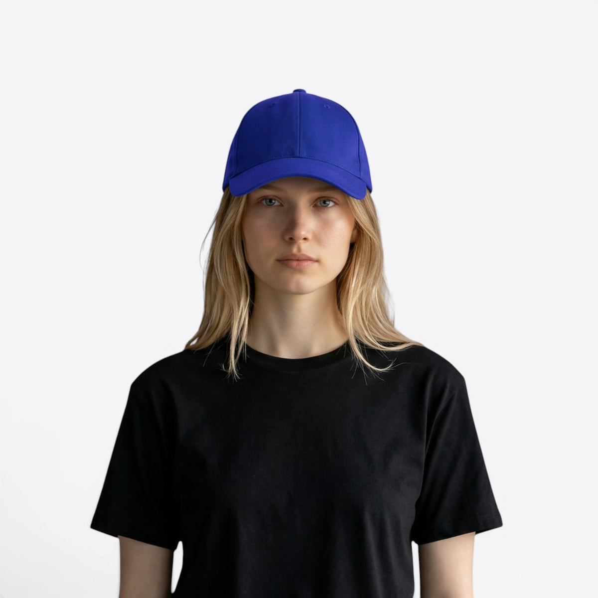 Personne blonde portant une casquette bleu roi, vue de face