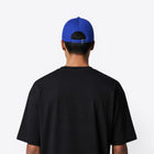 Personne aux cheveux courts portant une casquette bleu roi, vue de dos