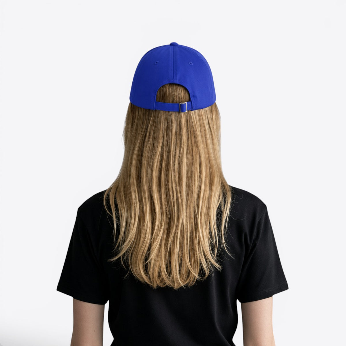 Personne blonde portant une casquette bleu roi, vue de dos